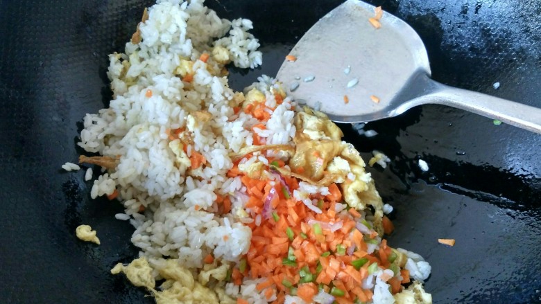 五彩炒饭,将胡萝卜丁倒入锅中，放适量的盐翻炒。