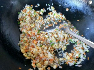五彩炒饭,将玉米粒，洋葱，青椒，倒入锅中，翻炒。