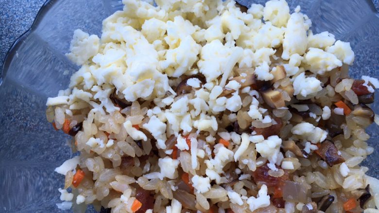 #剩米饭的百种做法#芝士鸡翅包饭,米饭放在碗里，一边倒上一些芝士