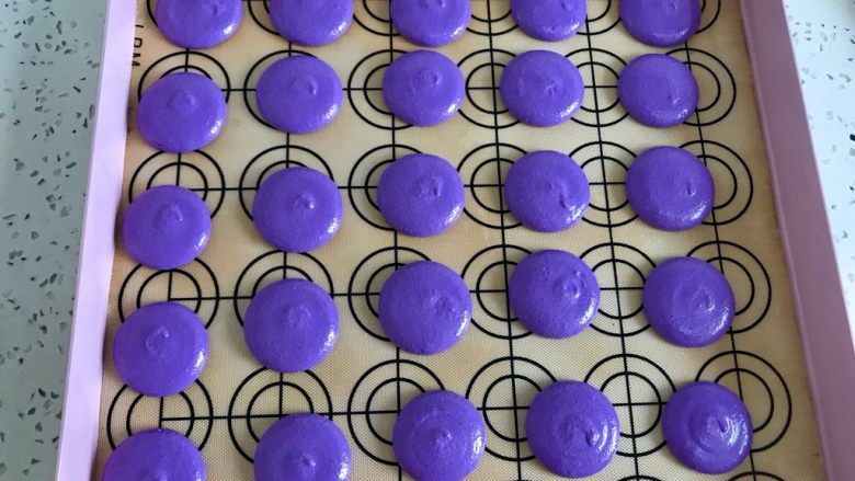 法式紫色马卡龙,开始挤入烤盘，一定要垂直，挤好以后震几下盘，把大气泡震出来，如果有气泡就用牙签挑一下。