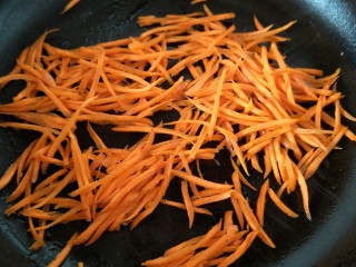 黄瓜胡萝卜拌粉丝,锅中加油加热后，把切成丝的胡萝卜放入锅中炒熟。