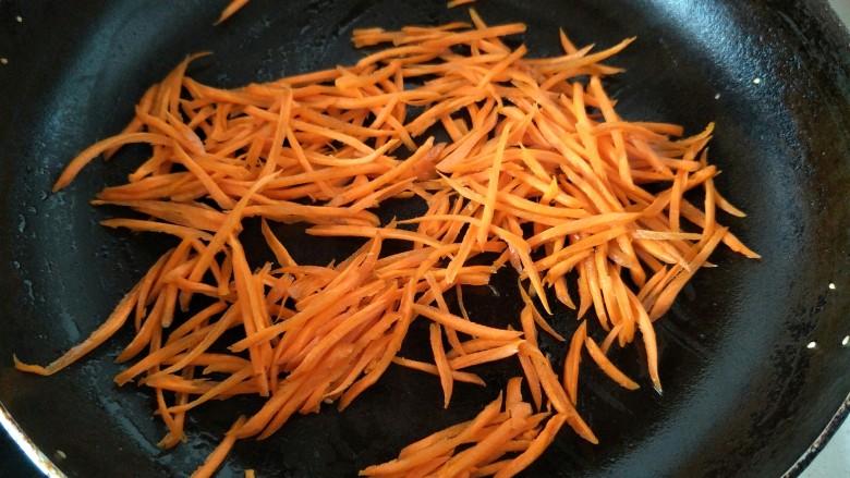 黄瓜胡萝卜拌粉丝,锅中加油加热后，把切成丝的胡萝卜放入锅中炒熟。