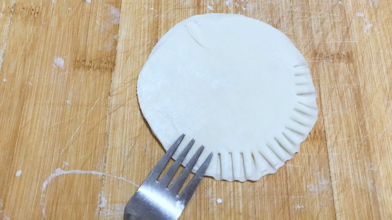 饺子皮版鸡蛋灌饼,准备一把叉子，用叉子得前端用力把两张饺子皮压紧。如图所示！