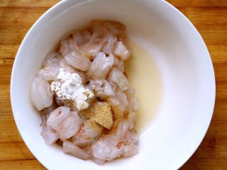 赛蟹肉版  炒虾仁,虾仁放在容器里，放入1小勺料酒，少许白胡椒粉和一小捏盐。