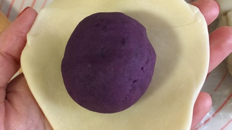 紫薯蛋黄酥详细版,包入紫薯蛋黄酥。虎口法封口。尽量封住紫薯。具体办法，右手虎口来回揉，左手旋转蛋黄酥。