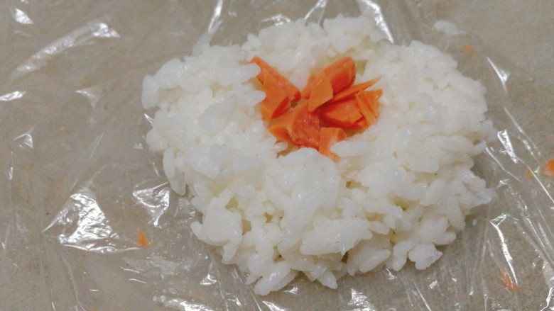 剩米饭百种做法+小老鼠抱蛋煎饭团,保鲜膜裹住一勺米饭，中间夹火腿粒
