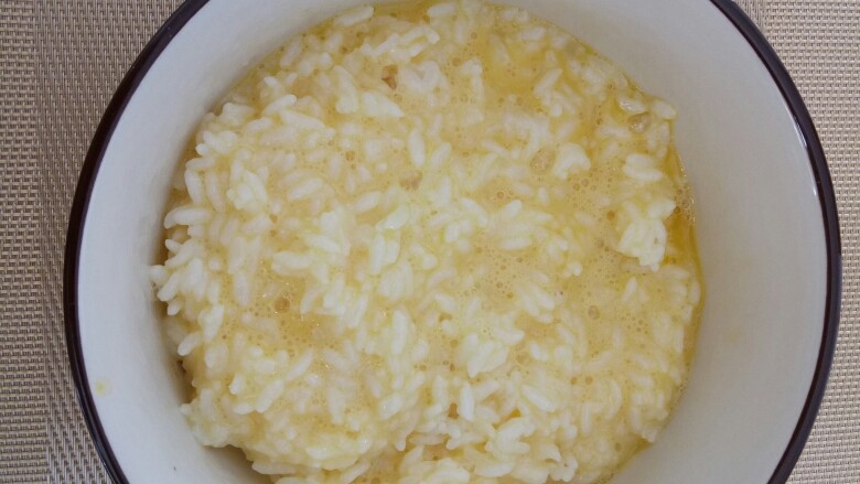 #剩米饭的百种做法#,放入剩米饭，用筷子搅拌，不能有结块现象。