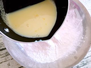 恐龙蛋,将蛋奶液趁热缓慢倒入麻薯粉中，边倒边搅拌