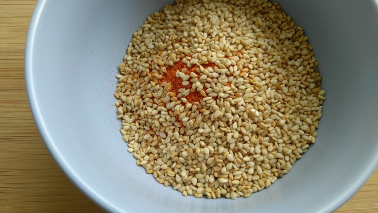 离不了的红油辣椒,芝麻炒熟后，倒入放有辣椒面的碗里。