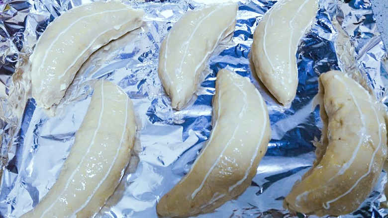 香蕉牛奶椰蓉包,在香蕉的表面挤上沙拉酱，顺着香蕉的弧度，很细很细的三条