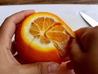 橙色水果汁,橙子去头去尾，表皮轻划四刀，可以轻松剥皮