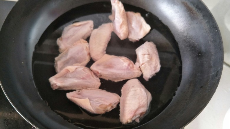 可乐鸡翅,锅里加水后加入鸡翅加热烧开焯水。