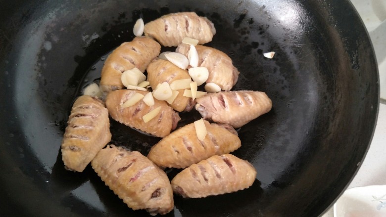 可乐鸡翅,然后放入葱段，姜片蒜片继续煸炒。