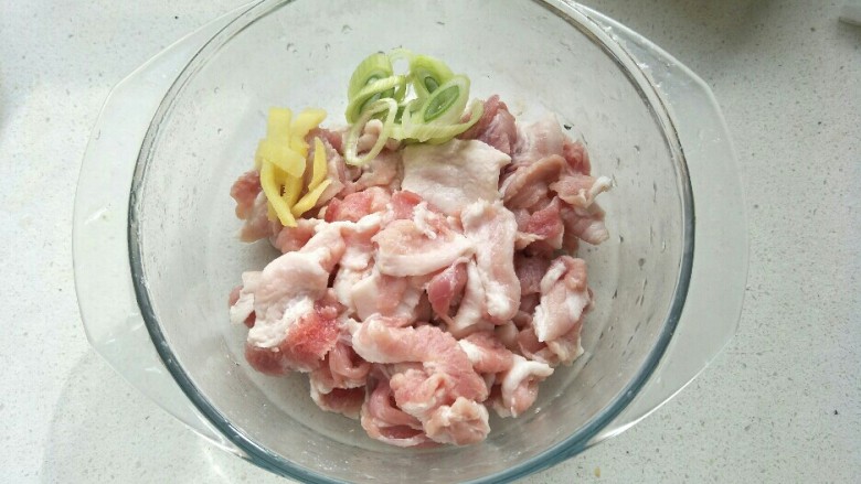 煎炸小酥肉,把葱姜放入装肉片的大碗中。