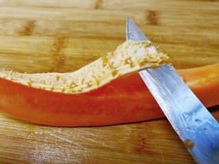 桃胶木瓜炖奶 #冬喝暖饮夏吃冰#,取一半木瓜，竖切成4块条状，用刀削去内囊，有籽的木瓜要去掉瓜籽和内囊。