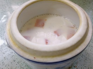 桃胶木瓜炖奶 #冬喝暖饮夏吃冰#,取一个炖盅，倒入煮好的桃胶木瓜奶液。