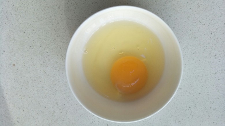 抱蛋煎饺,拿一个鸡蛋打入在小碗中。
