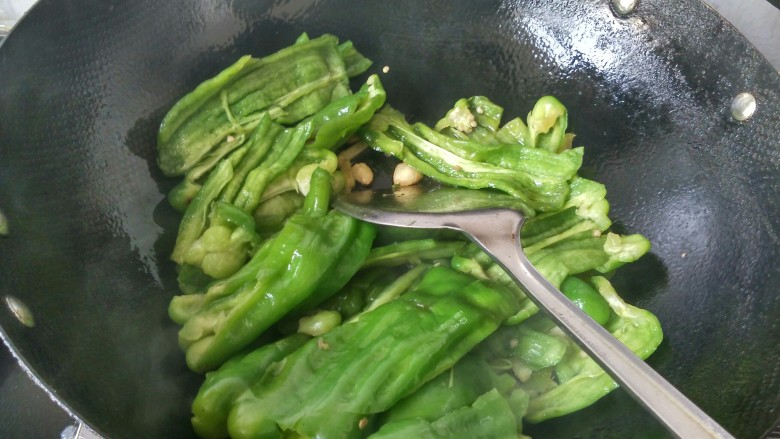 虎皮青椒,倒入七成熟的青椒，翻炒。