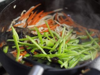 鱼香杏鲍菇,待物料变得油润软塌了，放入青椒丝和木耳丝，略翻炒。