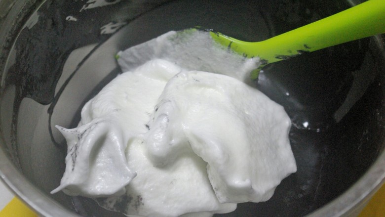 奥利奥竹炭卷,用刮刀取约三分之一蛋白霜加入蛋黄糊中，用切拌手法快速混合均匀，不可划圈，防止消泡。