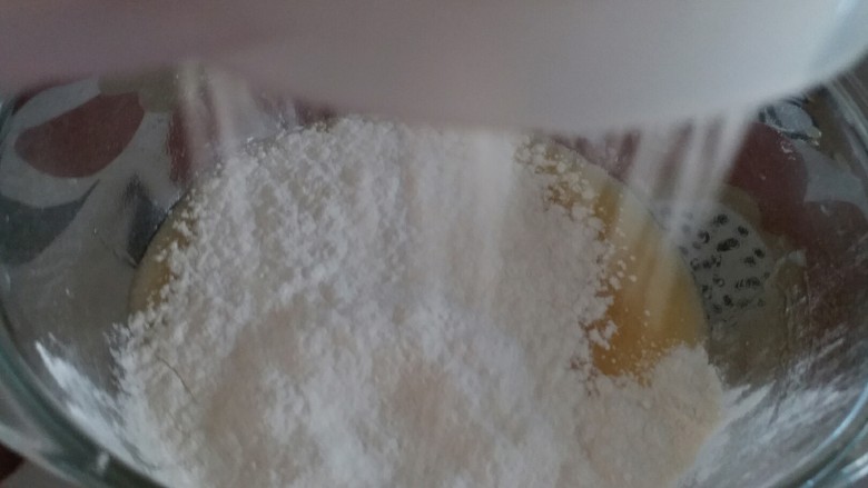 葡萄干花生酥（低糖低油版）,低筋粉和泡打粉过筛在蛋液碗中
