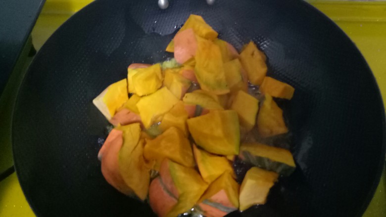 东北名菜#南瓜炖土豆#,加入适量酱油、耗油，在放入南瓜块，不断翻炒。