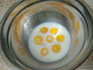 家有烤箱蛋黄肉松奶酪包,在蛋黄盆里加入牛奶，搅拌成蛋黄牛奶液。