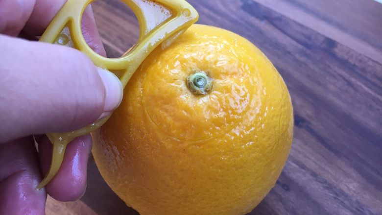 #冬喝热饮夏吃冰# 自制鲜橙汁,用剥皮器先在橙子的顶部割一个直径为4厘米的圆。