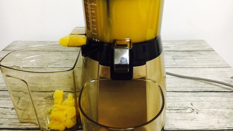 #冬喝热饮夏吃冰# 自制鲜橙汁,启动榨汁机工作按钮后，橙汁很快被榨出。