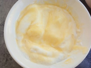 松软可口～戚风蛋糕（六寸版）,取出1/3的蛋清和之前拌好的蛋黄混合，用橡皮刮刀切拌均匀