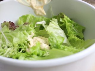 凯撒沙拉,生菜用手掰成小块，放入沙拉盆里，加入调好的沙拉酱拌开。