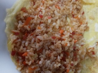 ＃剩米饭的百种做法之米饭蛋卷＃,炒好的饭铺在蛋饼上压实，卷起来