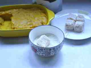 椰香牛奶南瓜糕 ,椰蓉倒入碗中，将切好的南瓜糕，放入碗里粘上椰蓉，然后装盘
