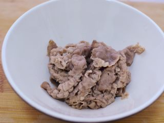 金针酸汤肥牛,肥牛用筷子夹出来放碗里。