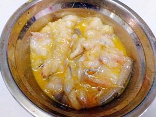 椒盐九肚鱼,取一个大碗，放入切好的九肚鱼，倒入蛋黄，胡椒粉抓匀渍腌。