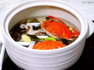 萝卜丸子&海鲜煲,砂锅中倒入适量的清水、把螃蟹、八爪蛸和小海螺放入锅中、加入海带、葱段和姜片、加适量盐放入锅中