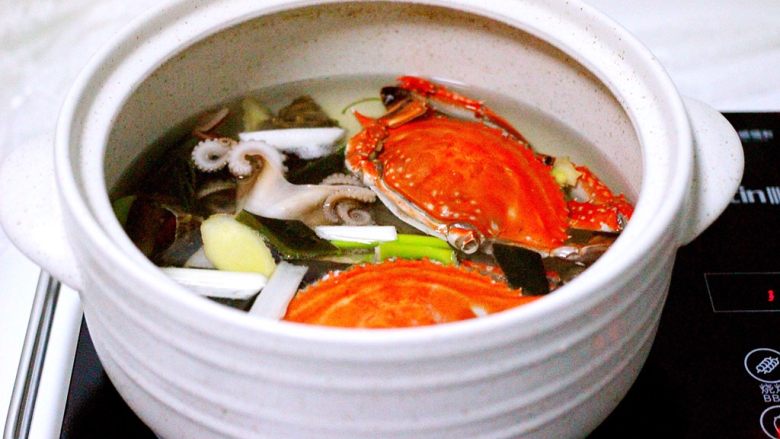 萝卜丸子&海鲜煲,砂锅中倒入适量的清水、把螃蟹、八爪蛸和小海螺放入锅中、加入海带、葱段和姜片、加适量盐放入锅中