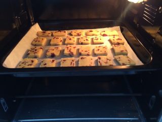 家有烤箱＃蔓越莓饼干,烤箱上下火165度，提前预热5分钟，放入烤盘，烤20分，表面上色即可。