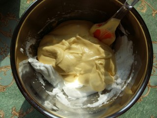 #家有烤箱#南瓜戚风杯子蛋糕,把混合均匀的蛋黄糊倒入剩下的蛋白中。翻拌均匀。