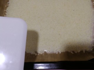 香酥芝麻瓦片,倒好后，端起烤盘，晃动将面糊弄匀，边缘用面刀刮齐。