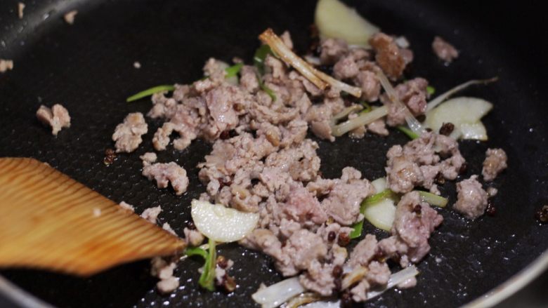 香辣干锅土豆片,放入猪肉糜划散至变色，淋一汤匙料酒。
