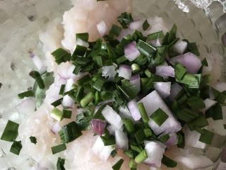 韭菜鱼饼,剁碎的鱼肉放入大碗后加入韭菜和洋葱末。