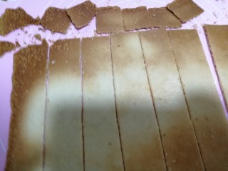 香酥芝麻瓦片,油布翻过来放好。用刀切成条，再切成方块儿。