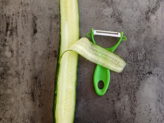 开胃爽口菜～浇汁黄瓜,用刮刀对准黄瓜的一头笔直往下刮成薄片