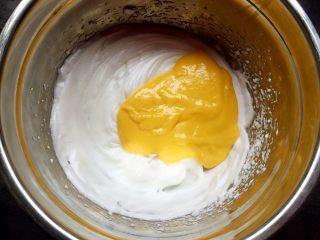 万圣节-鬼脸杯子蛋糕,将蛋黄糊倒入蛋清中，用翻拌的方法拌匀。