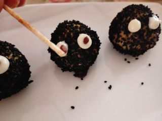 万圣节之黑芝麻球——蜘蛛&小精灵,小圆球上用沙拉酱挤上两个眼睛，中间用巧克力点睛，小精灵就做好了，