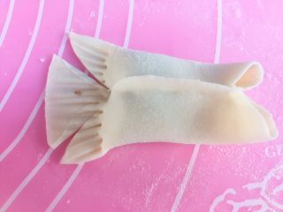 金鱼蒸饺(酸菜油脂拉馅),用剪子在尾巴处剪两刀，如图。