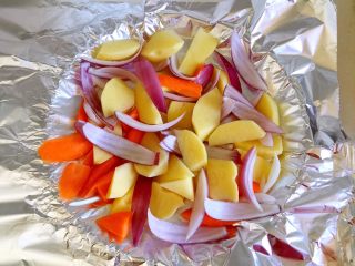 烤羊排,将洋葱、土豆和胡萝卜放入铺了锡纸的烤盘上。