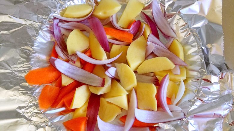 烤羊排,将洋葱、土豆和胡萝卜放入铺了锡纸的烤盘上。