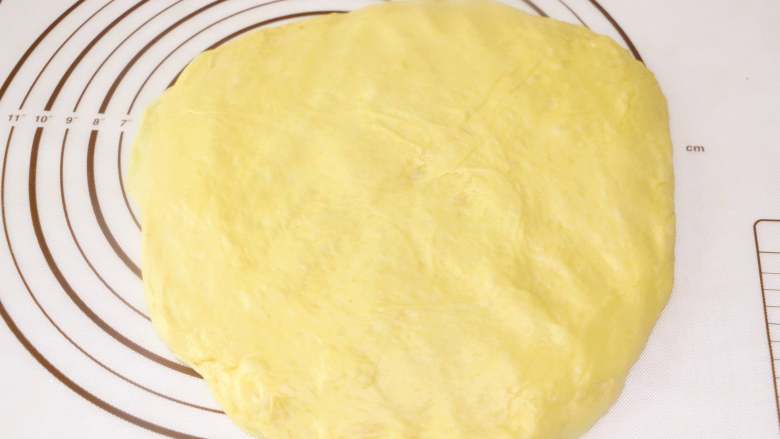 麻糍蜜豆萝卜餐包,将发酵好的面团放在揉面垫上按压排气